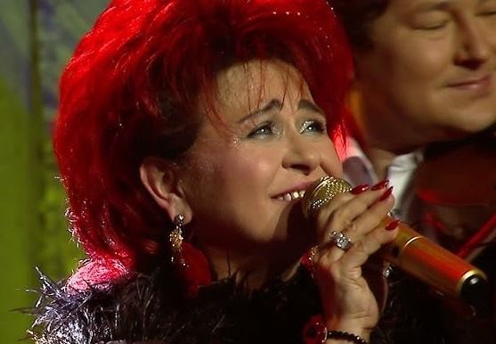 Bernadeta Kowalska przeglądająca media społecznościowe na telefonie lub wchodząca w interakcję z fanami online, ukazująca jej aktywność na Instagramie i Facebooku.