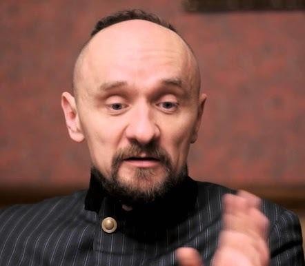 Jan Klata w trakcie próby teatralnej, gestykulujący, co oddaje jego aktywną rolę reżysera w procesie twórczym.