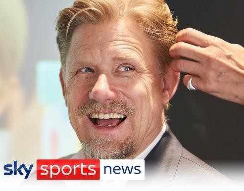 Peter Schmeichel w akcji, wykonujący paradę bramkarską, z widocznym skupieniem i wyciągniętymi rękami.