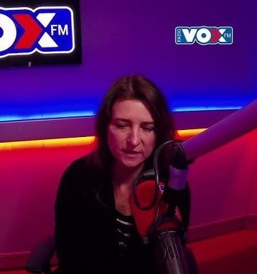 Renata Dąbkowska śpiewająca na scenie, w eleganckim stroju koncertowym, w blasku świateł scenicznych.