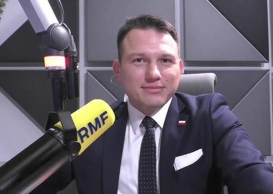Sławomir Mentzen podczas wystąpienia publicznego, z wyrazistą mimiką, oddającą jego kontrowersyjne poglądy polityczne.
