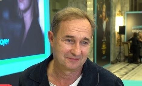 Marek Kalita reżyserujący spektakl teatralny, gestykulujący w stronę sceny.