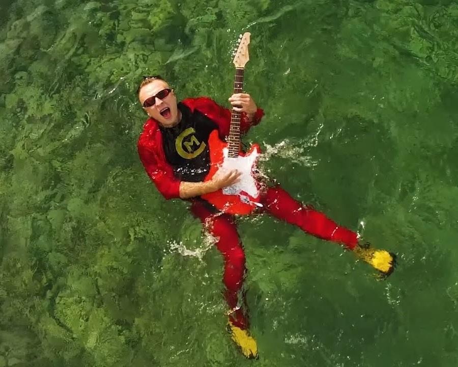 Czadoman w trakcie energicznego występu na scenie, otoczony tancerzami i efektami świetlnymi, oddający atmosferę koncertu disco polo.