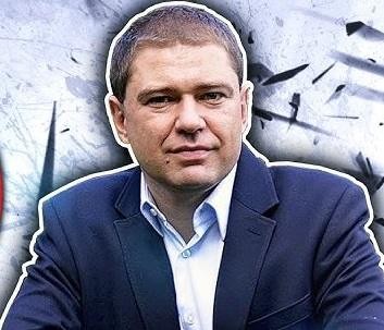 Piotr Szumlewicz przemawiający na wiecu związkowym, z mikrofonem w dłoni, w tle widoczny tłum ludzi z transparentami, symbolizujący jego rolę lidera i obrońcy praw pracowniczych.