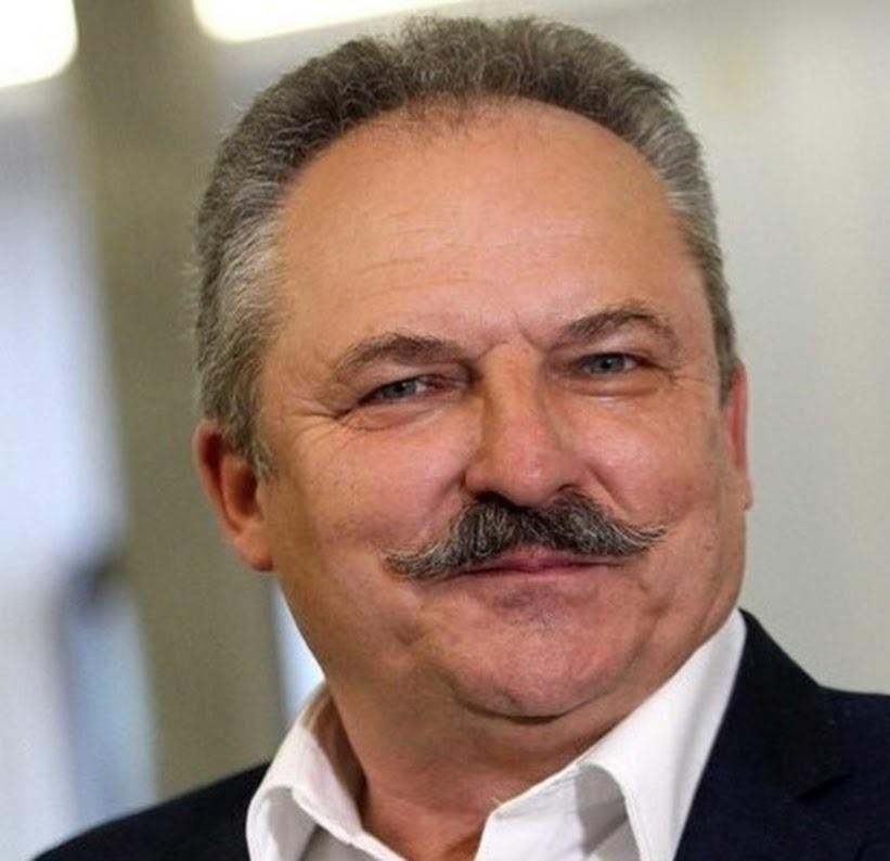 Marek Jakubiak podczas wystąpienia publicznego, z gestykulacją, na tle zgromadzonych ludzi.